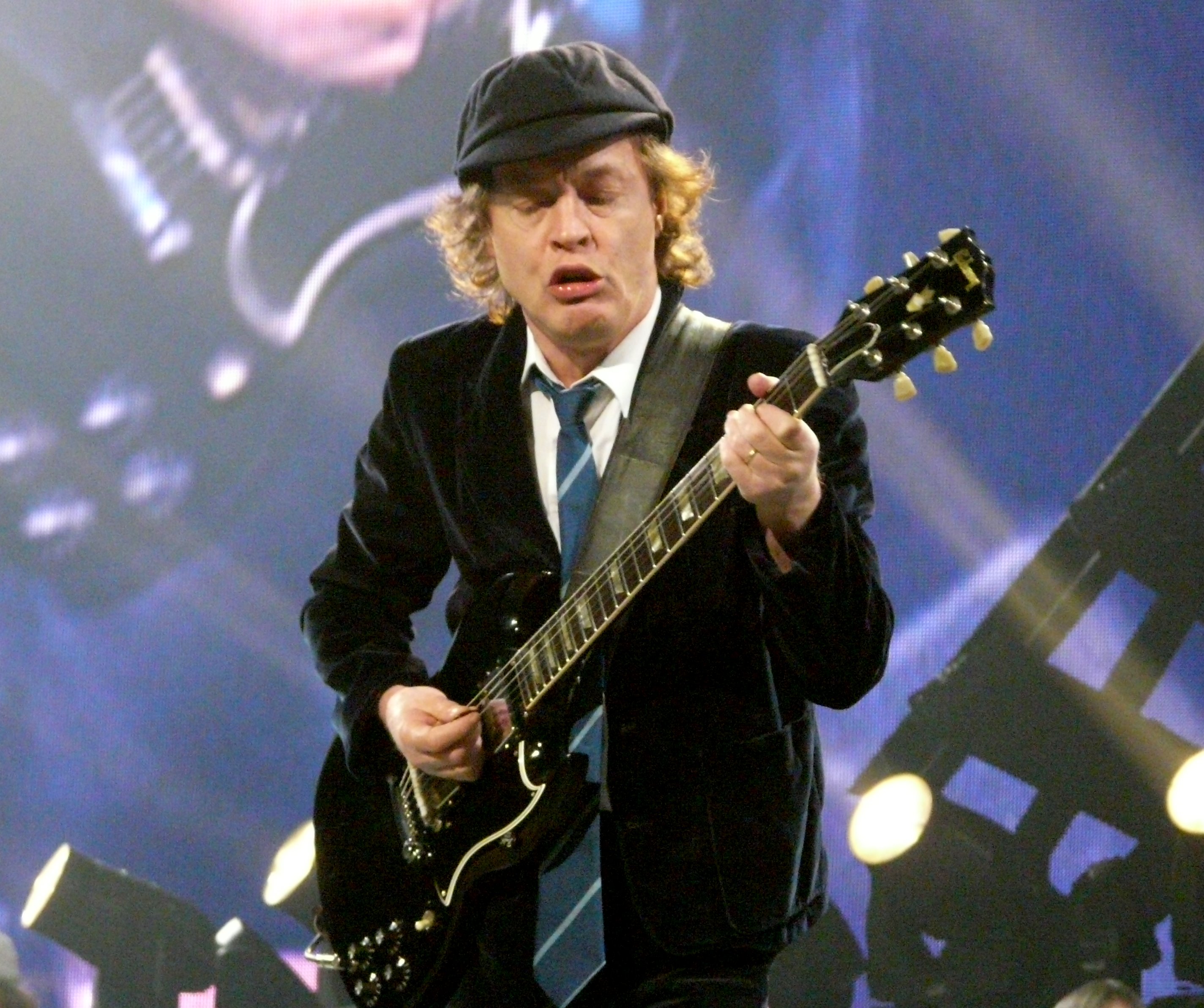 Angus Young performing on stage with his Gibson SG guitar