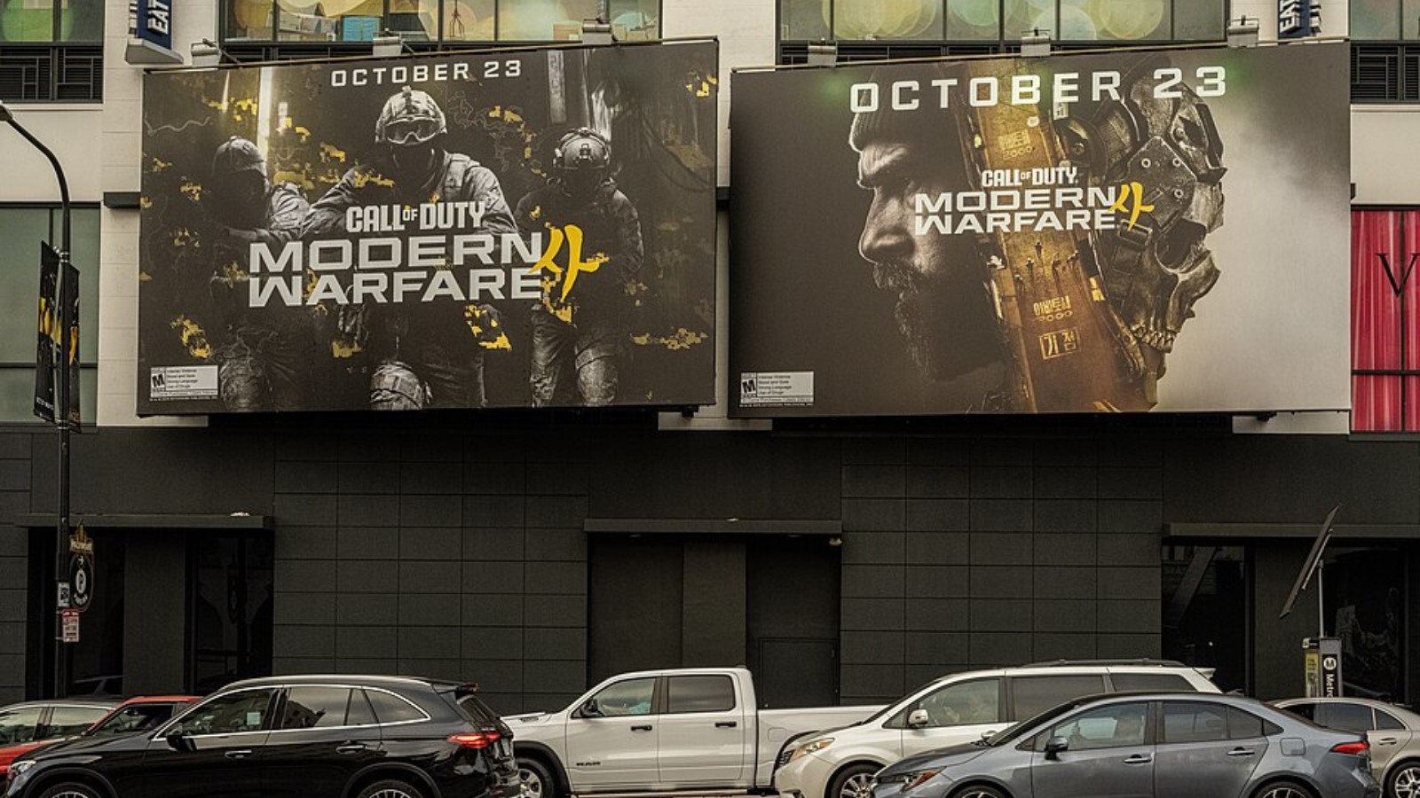 Two giant Modern Warfare 4 launch billboards on a city building, dated October 23, above street traffic