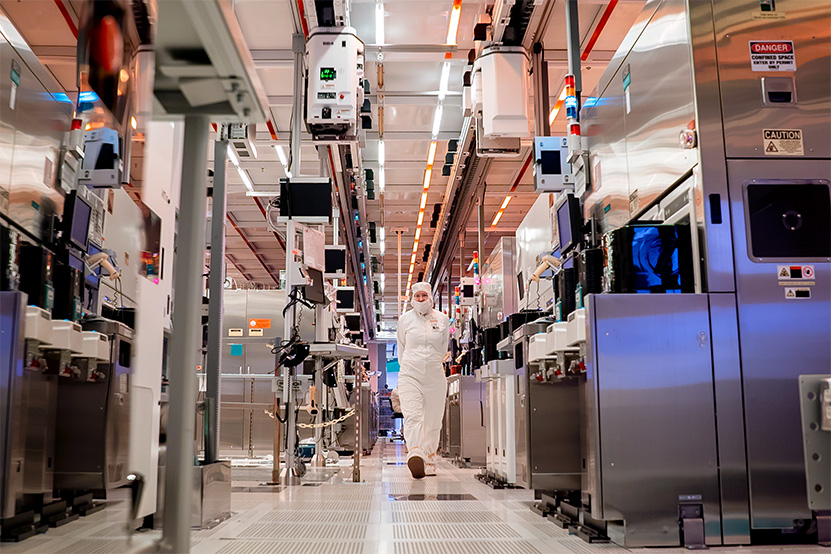A worker walks through a chip fabrication cleanroom.