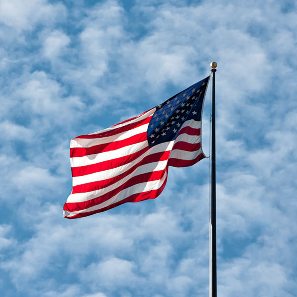 An American flag waving against a blue sky.