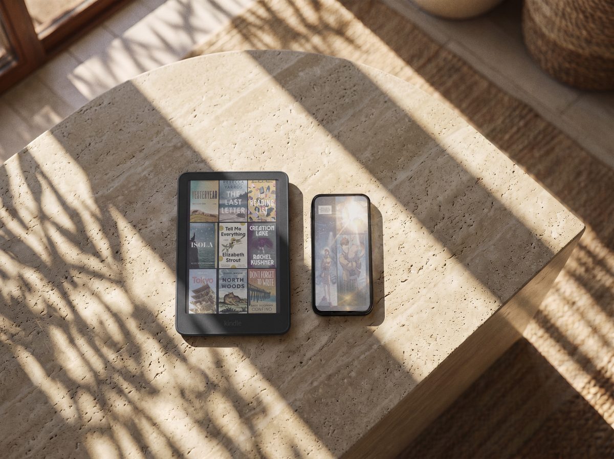 The new Kindle Colorsoft displaying book covers in paper-like color, resting on a sunlit stone table