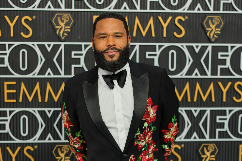 Anthony Anderson hosting on stage at an awards show