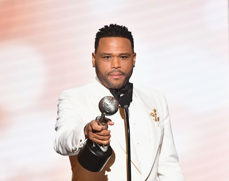 Anthony Anderson in a white tuxedo holding an NAACP Image Award trophy