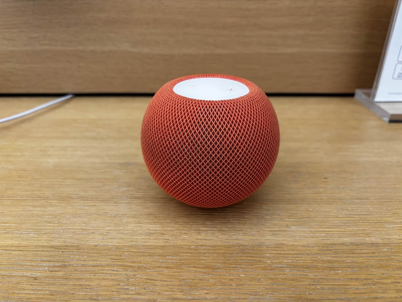 An orange Apple HomePod mini on a desk — the smart speaker at the center of Apple's October 13 event