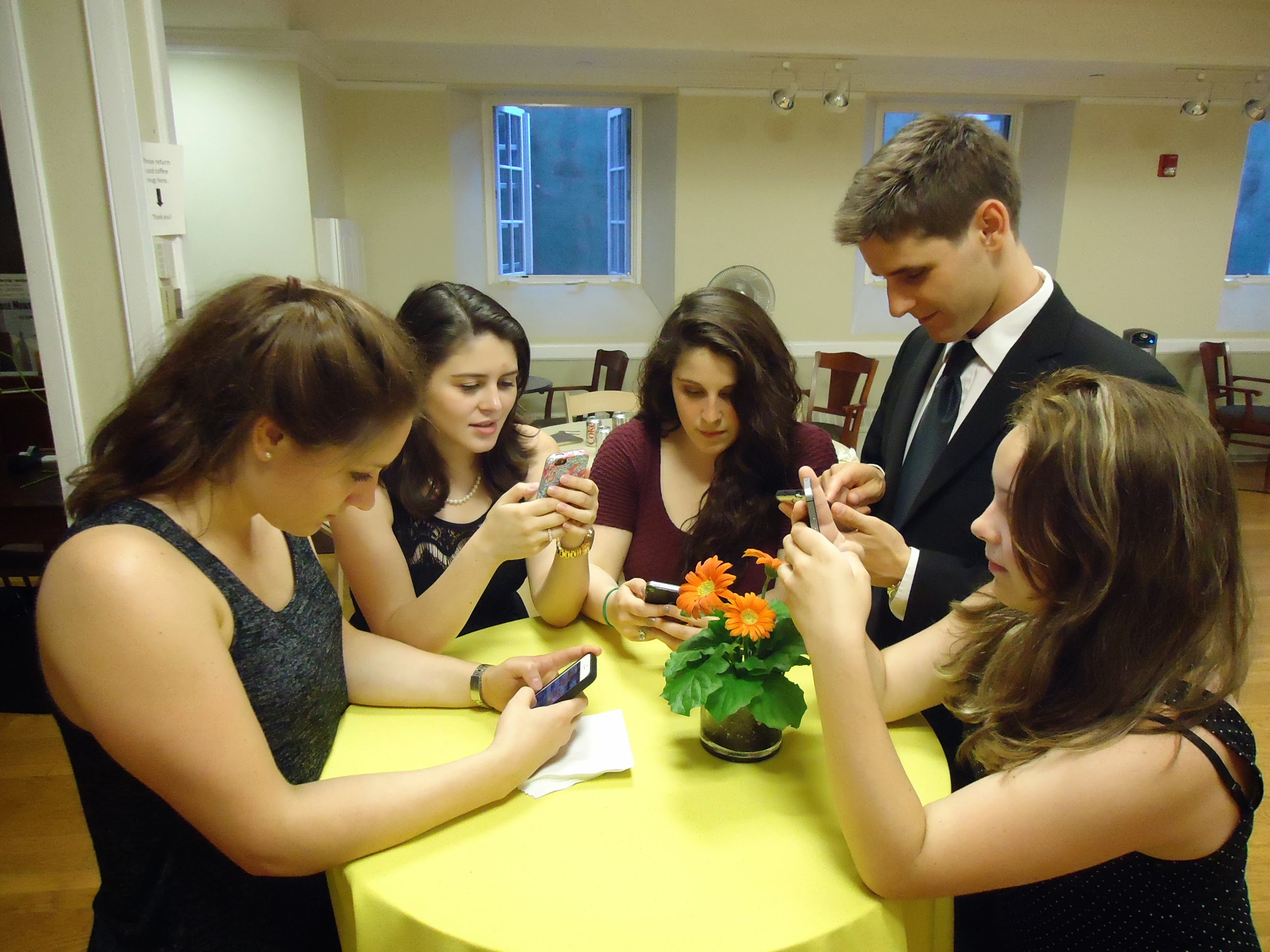 Young people using smartphones, a reference to the online spaces the law addresses