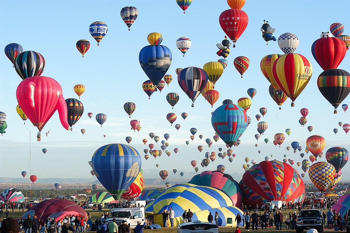 Dozens of hot-air balloons filling the sky over Balloon Fiesta Park during a mass ascension