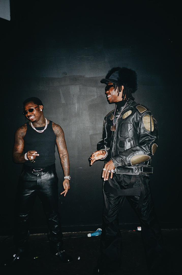 Blaqbonez and Asake laughing together in a dark studio during the Chanel sessions