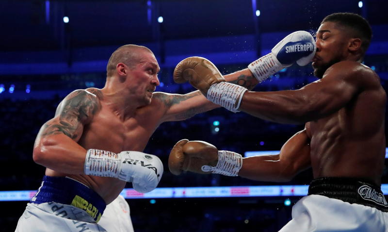 Two boxers trading punches under bright arena lights.