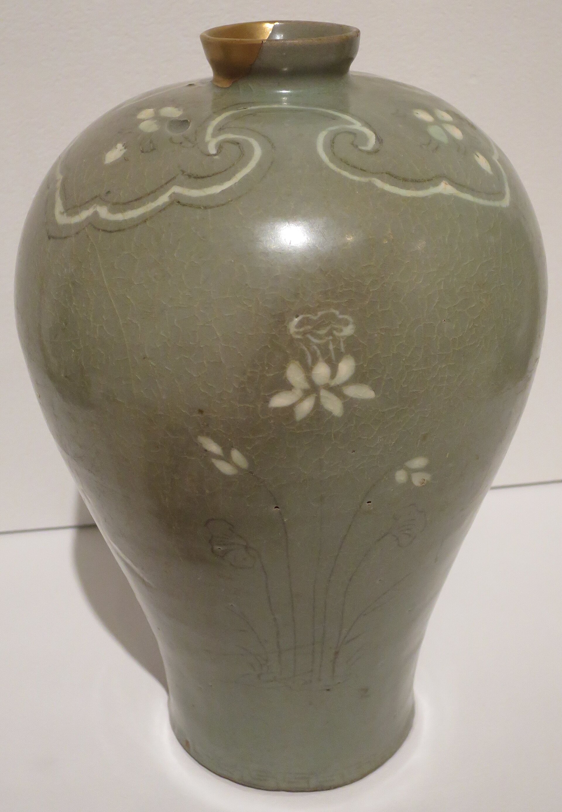 A Goryeo-dynasty celadon maebyong vase with white-inlaid decoration and jade-green glaze