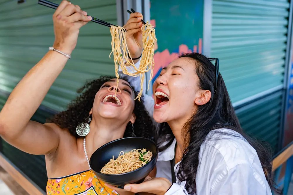 Friends sharing bowls of spicy instant noodles together