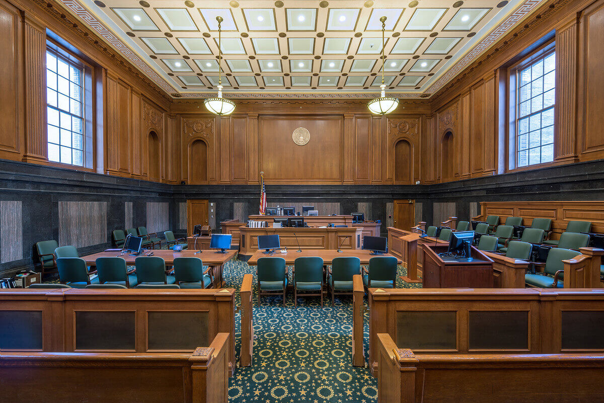 A bright, wood-paneled courtroom with tall windows.