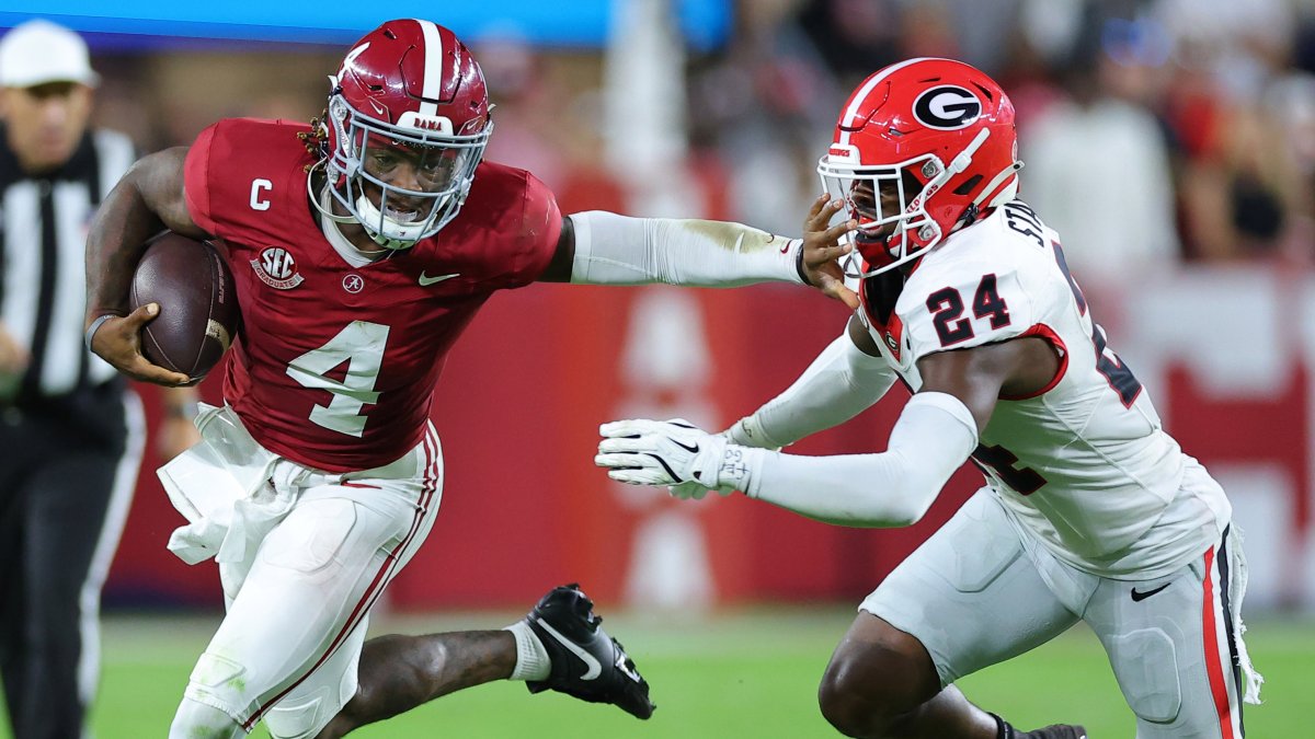 An Alabama ball carrier stiff-arms a Georgia defender during game action between the Crimson Tide and the Bulldogs