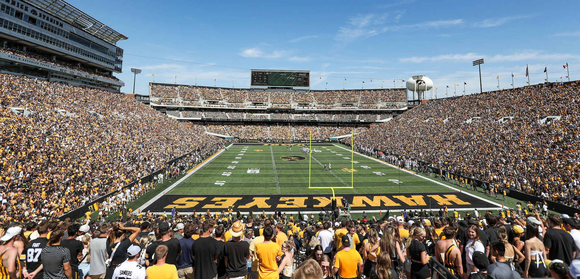 Kinnick Stadium in Iowa City packed with fans under a bright blue sky