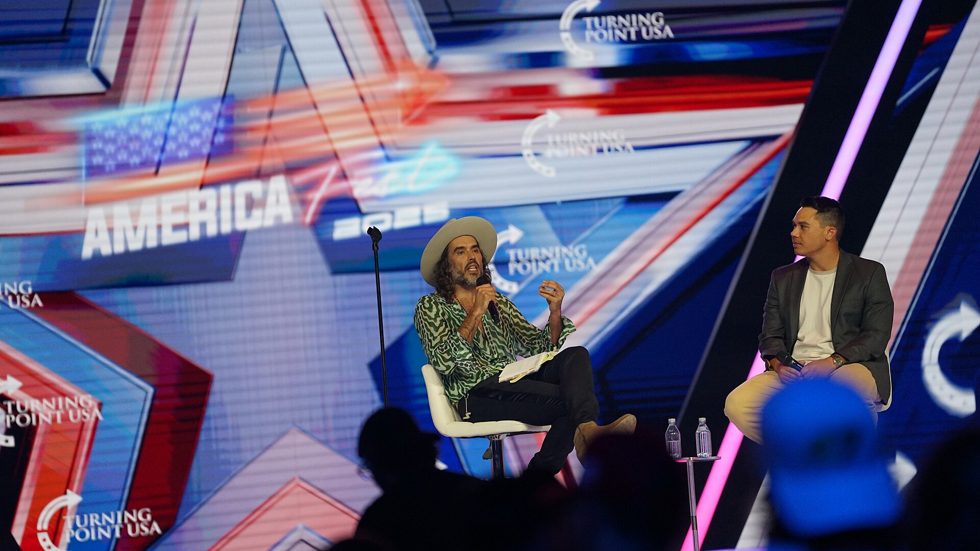 Russell Brand on stage at AmericaFest 2025