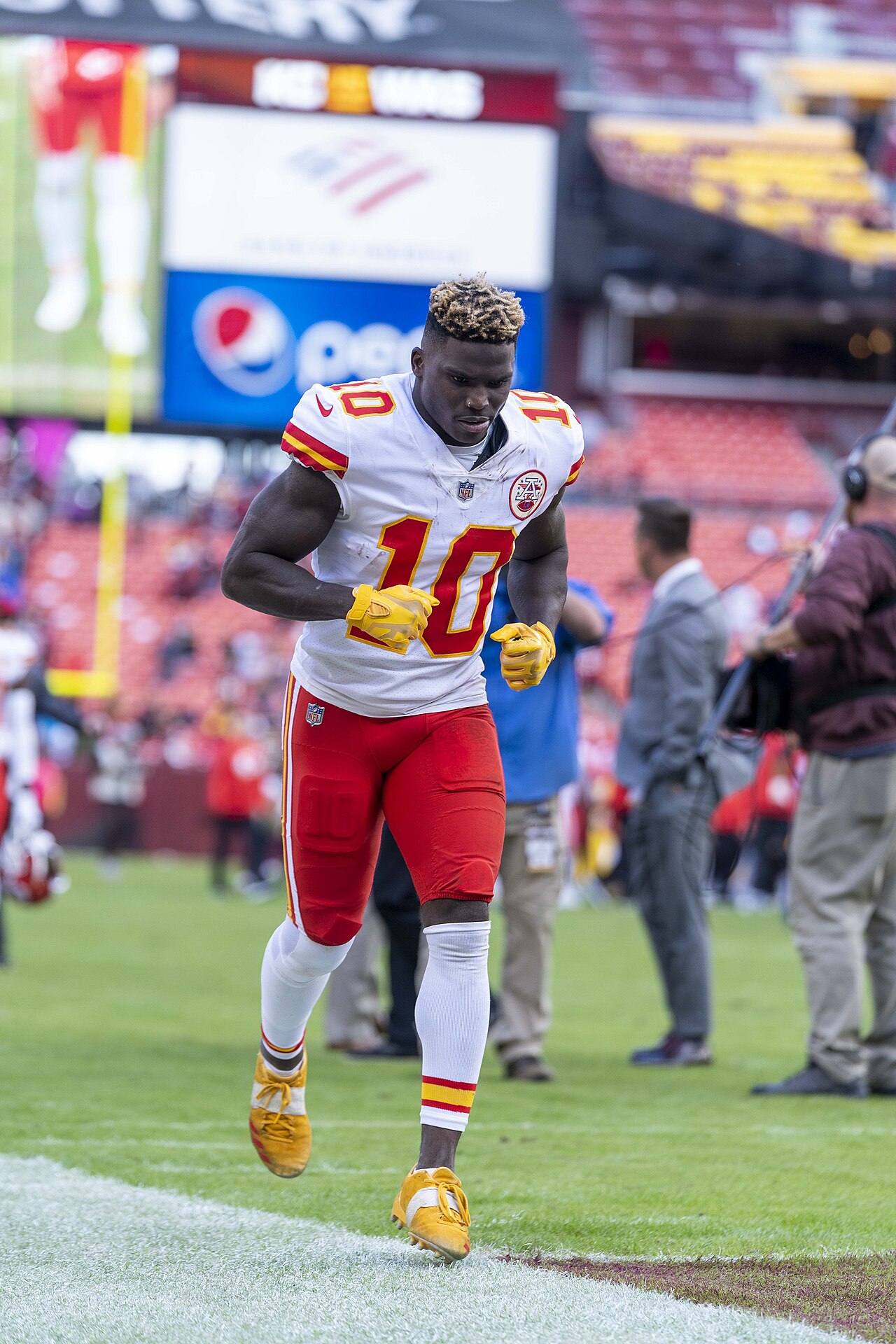 Tyreek Hill wearing a white Kansas City Chiefs No. 10 uniform on the field during his first stint with the team.