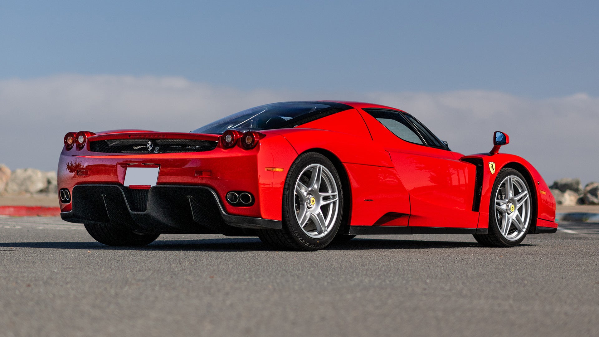 Broad Arrow's 2003 Ferrari Enzo in Rosso Corsa, rear three-quarter view — the actual car offered at the 2026 Las Vegas Auction