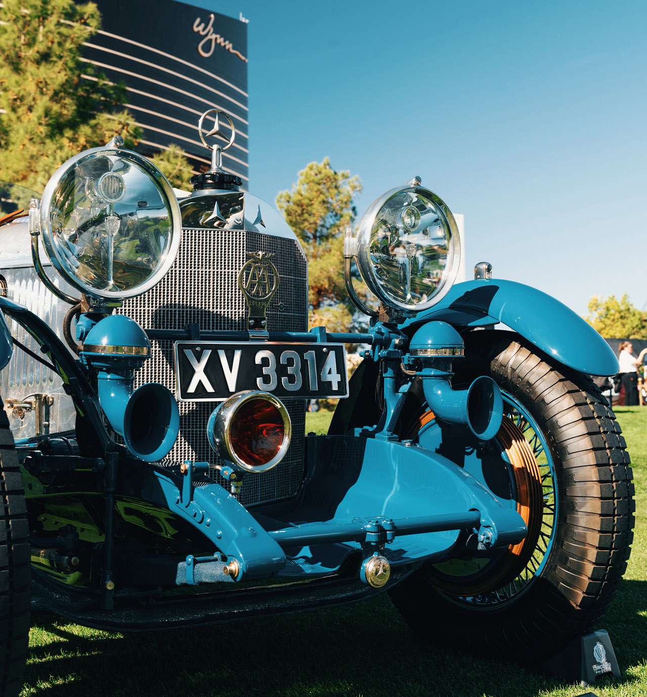 Front detail of the blue 1929 Mercedes-Benz 680 S Barker Tourer — twin headlamps, horns and the three-pointed star — on the Wynn grass; last year's Pre-War Helene Award winner