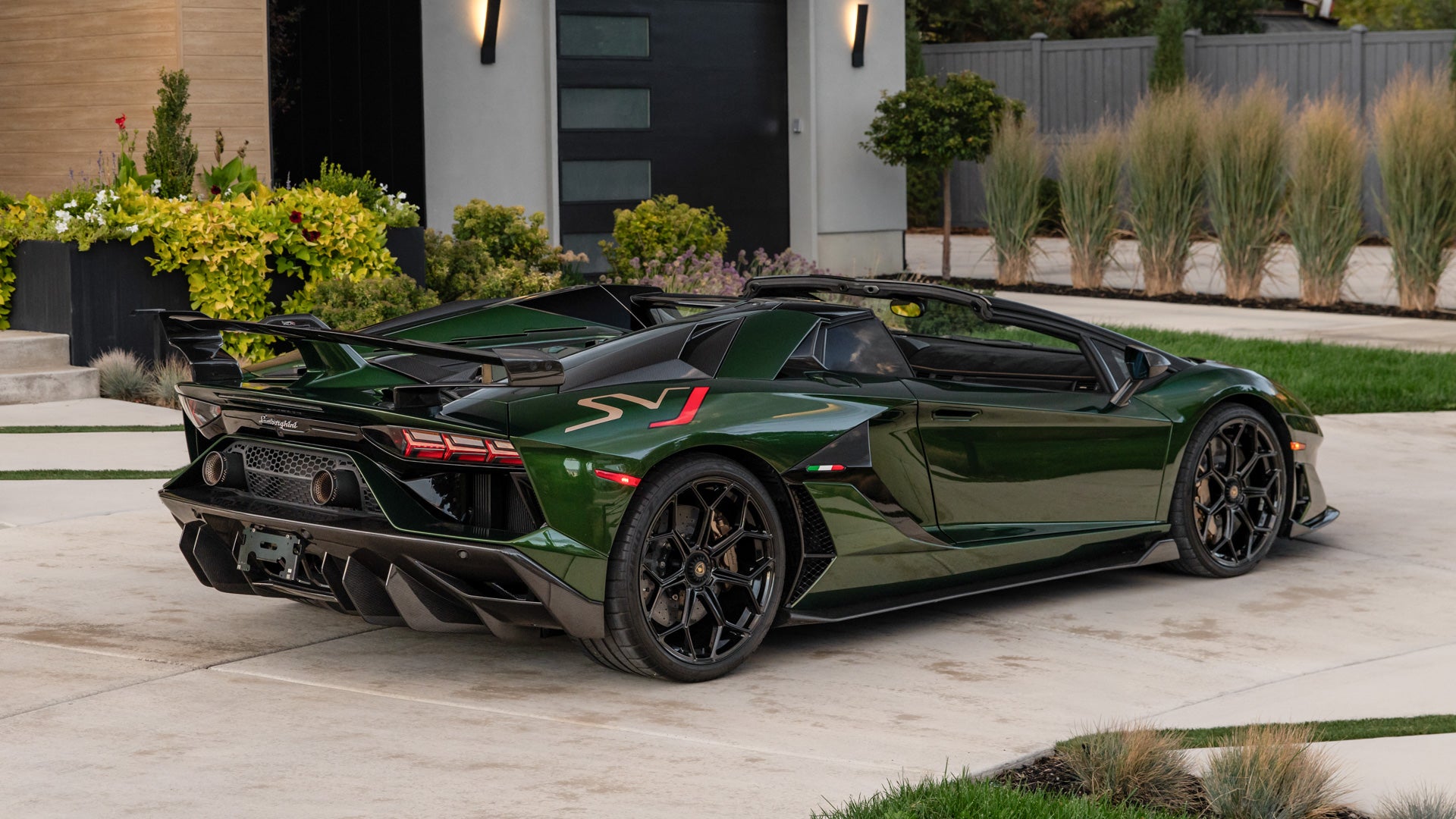 The 2021 Lamborghini Aventador SVJ Roadster in Verde Ermes with its roof panels removed, rear three-quarter view — the actual car offered at the 2026 Las Vegas Auction