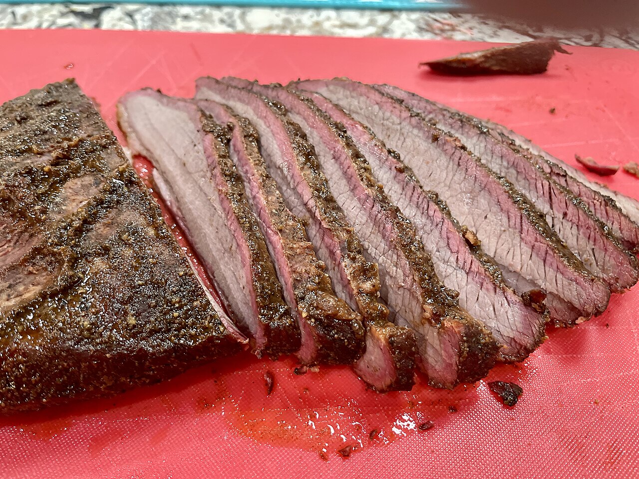 Slow-smoked beef brisket with a deep smoke ring, fresh off the pit