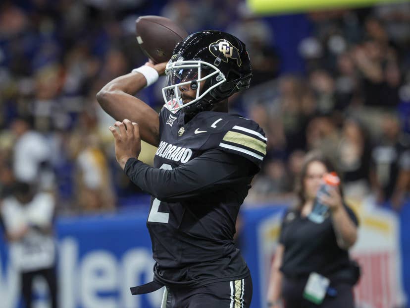 A Colorado quarterback in the black home uniform throwing a pass