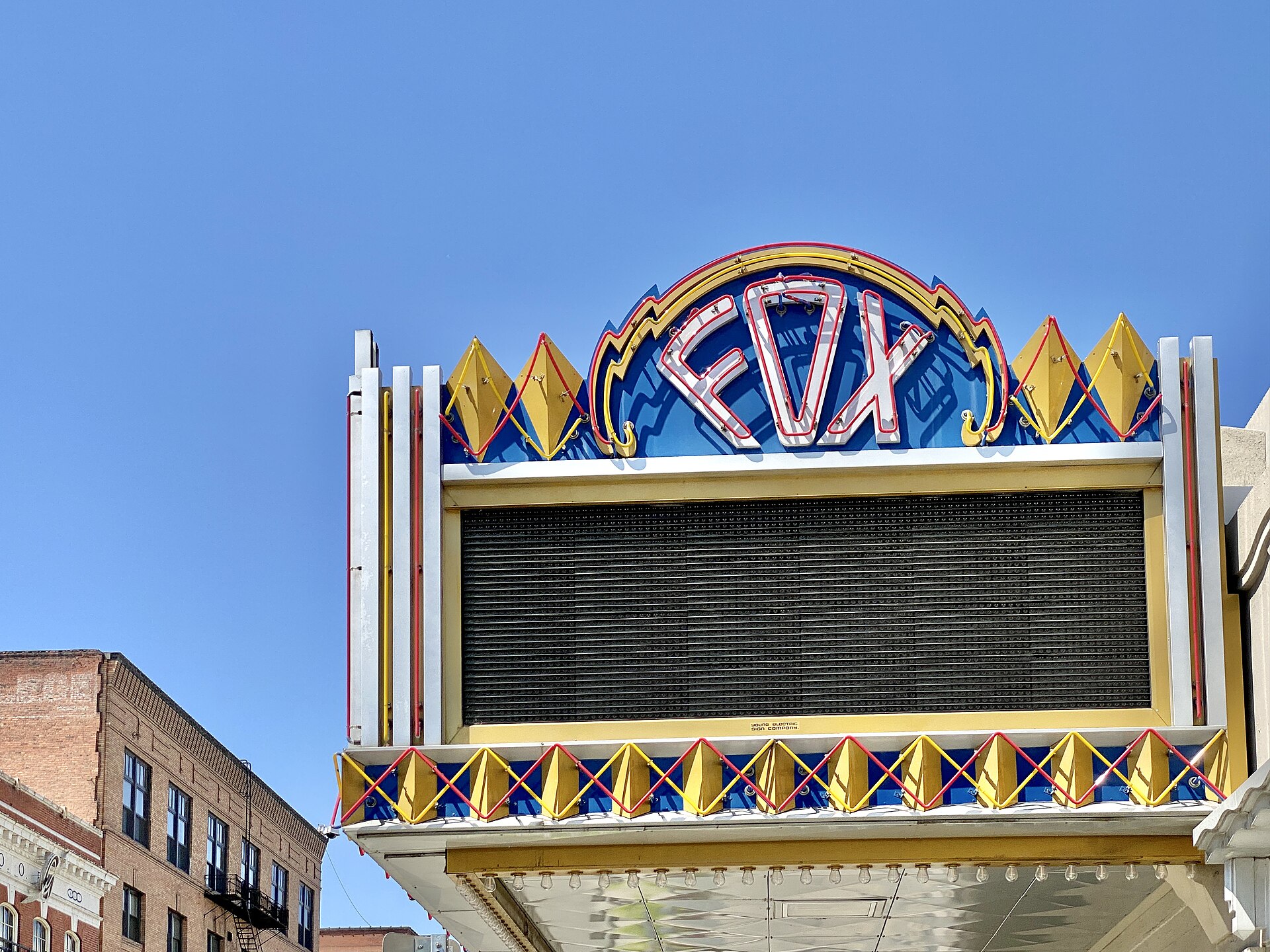A grand old movie palace marquee lit in the evening