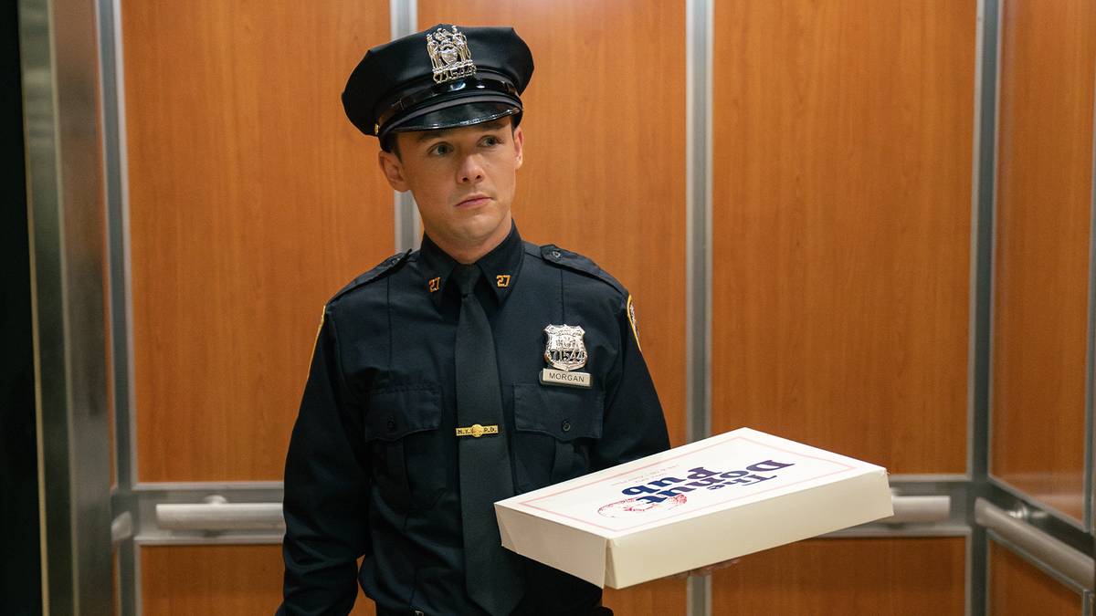Harrison Morgan, played by Jack Alcott, in his NYPD uniform holding a box of donuts in an elevator — Dexter: Resurrection season 2 premiere still