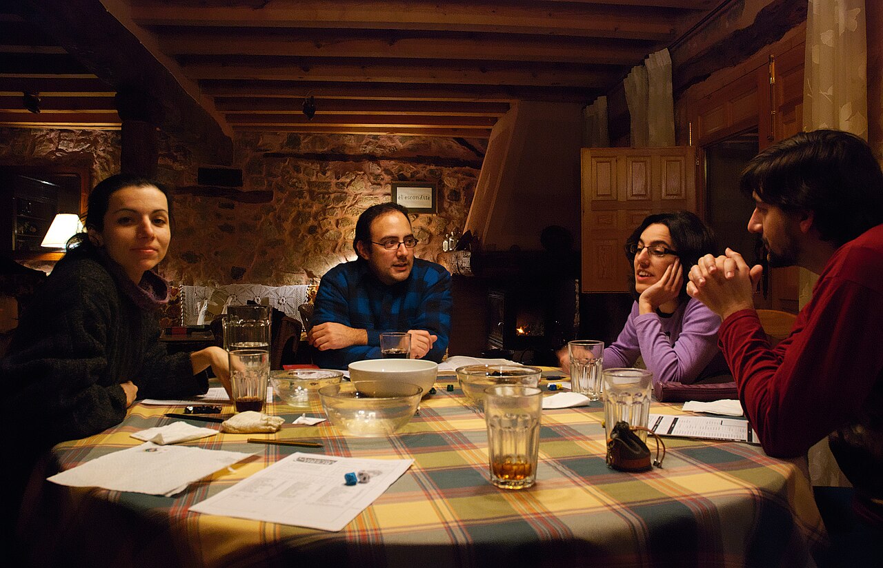 A group of role-playing gamers around a table with dice, snacks and character sheets