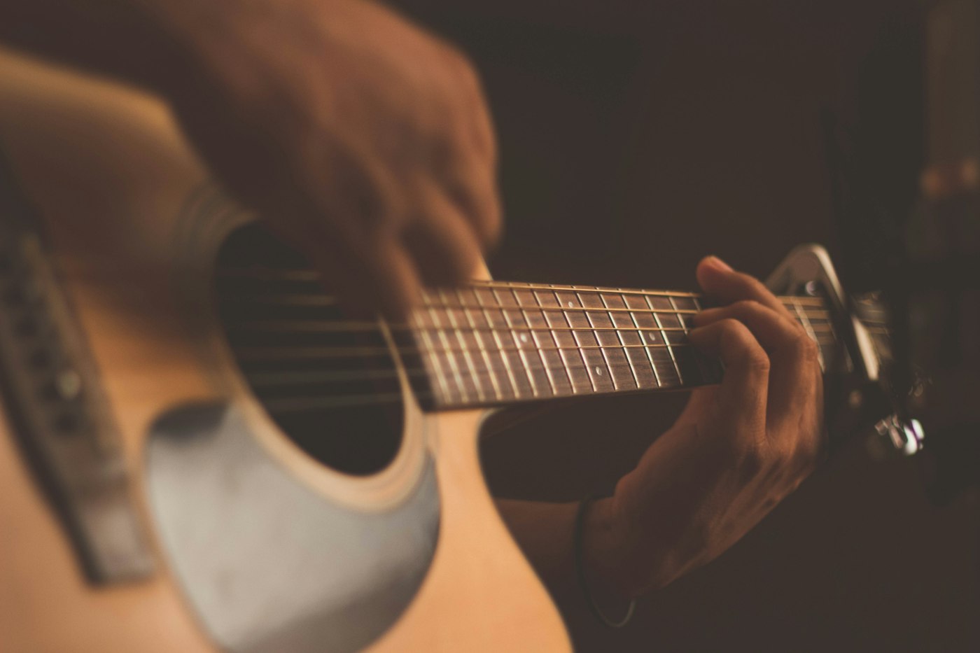 An acoustic guitar resting in warm stage light