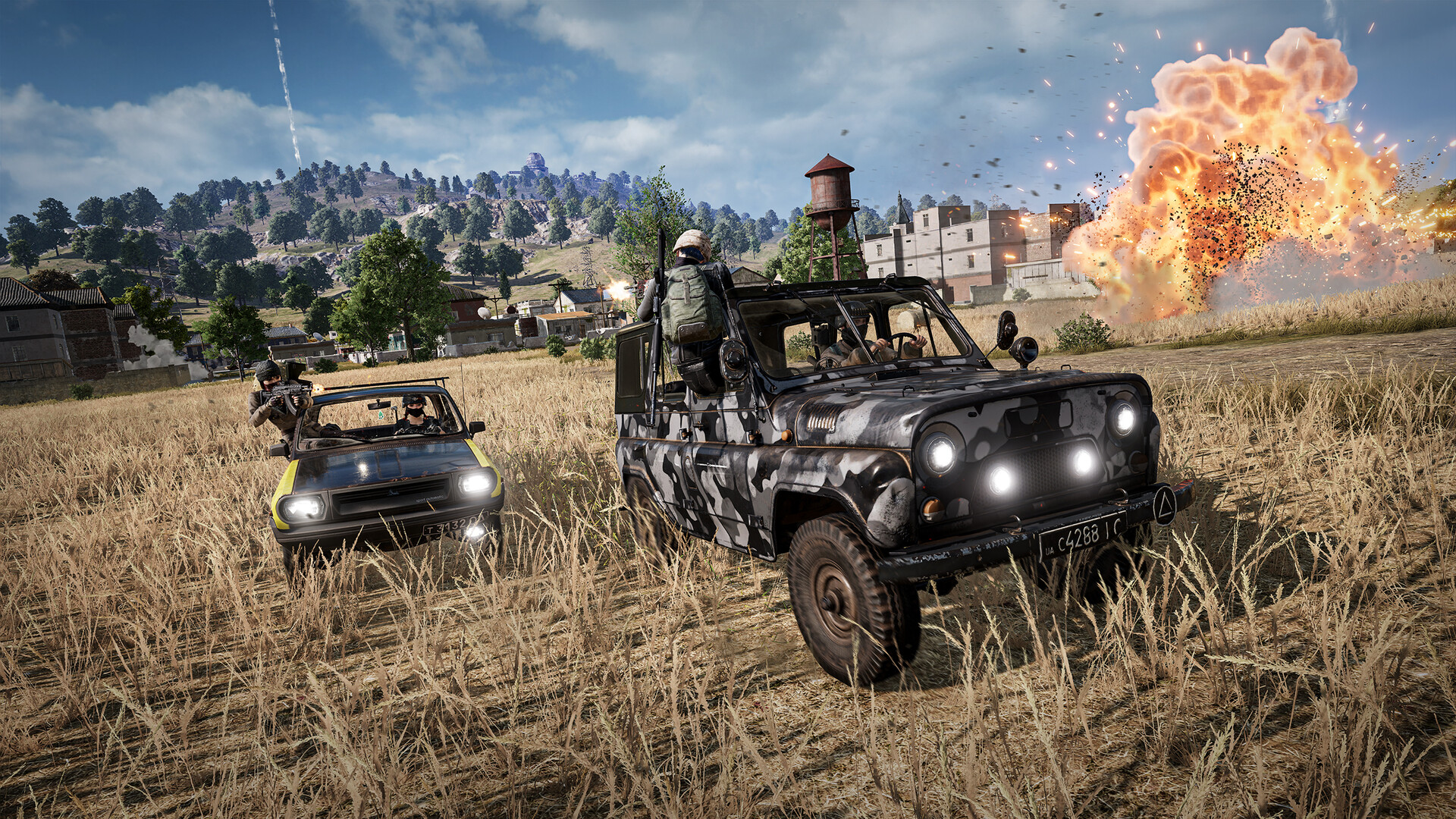 Official PUBG gameplay screenshot — a vehicle chase across an open field as an explosion goes off