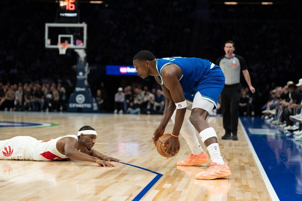 Anthony Edwards of the Minnesota Timberwolves holds the ball as Toronto Raptors guard Ja'Kobe Walter lies on the floor during the first half at Target Center in Minneapolis on October 25, 2026