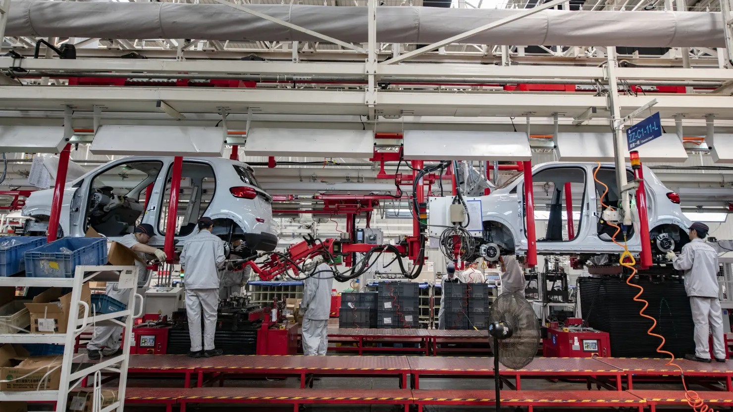 Workers assembling electric vehicles on a Chinese factory production line