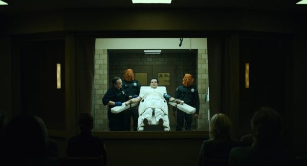 John Leguizamo as Father Sunday strapped to an execution table in The Exorcist: Martyrs