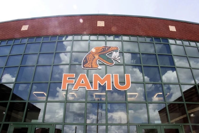 The glass-and-brick facade of a Florida A&M University building in Tallahassee, with the orange Rattlers snake logo and FAMU lettering across the windows