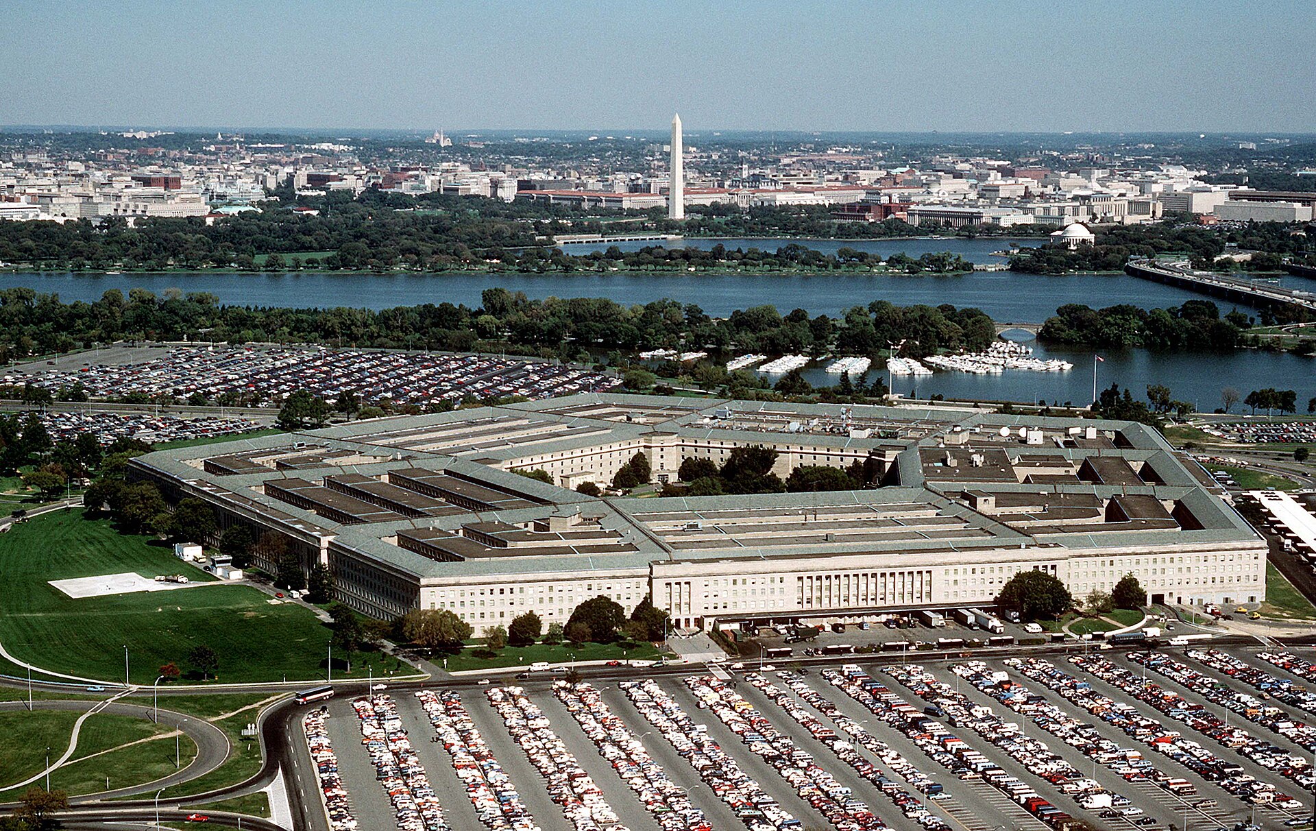 An aerial view of the Pentagon in Arlington, Virginia, in daylight, with the Washington Monument beyond