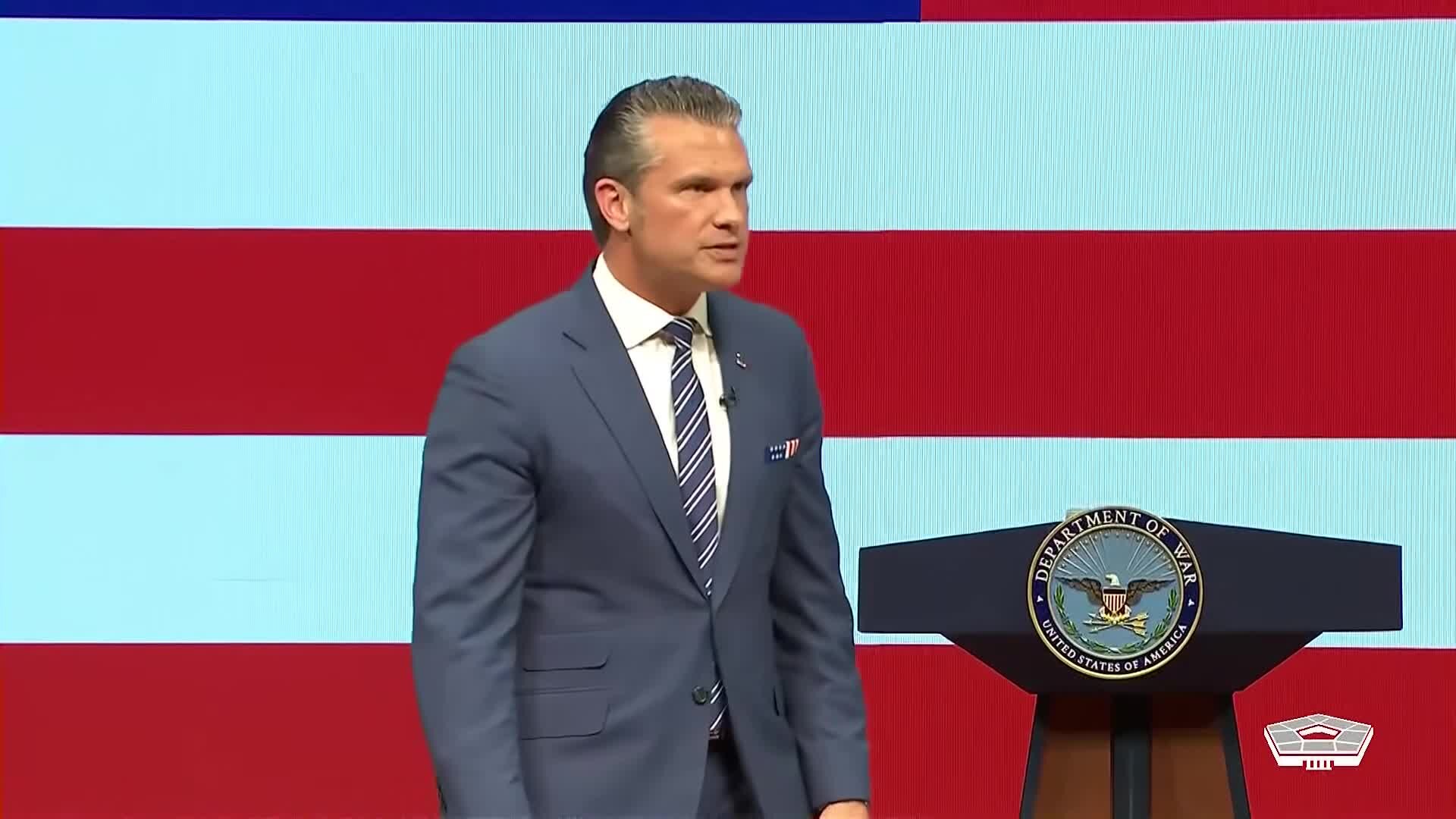 Secretary of War Pete Hegseth speaking at a Department of War podium during his State of the Force address at Marine Corps Base Quantico