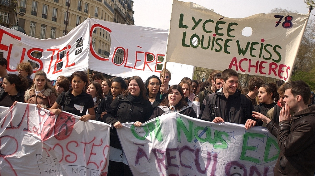 High school students march with banners in France, including one reading Lycée Louise Weiss Achères