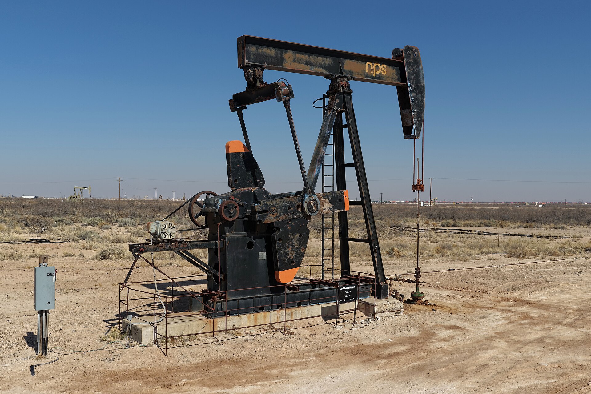 An oil pumpjack working in the Permian Basin under a clear sky
