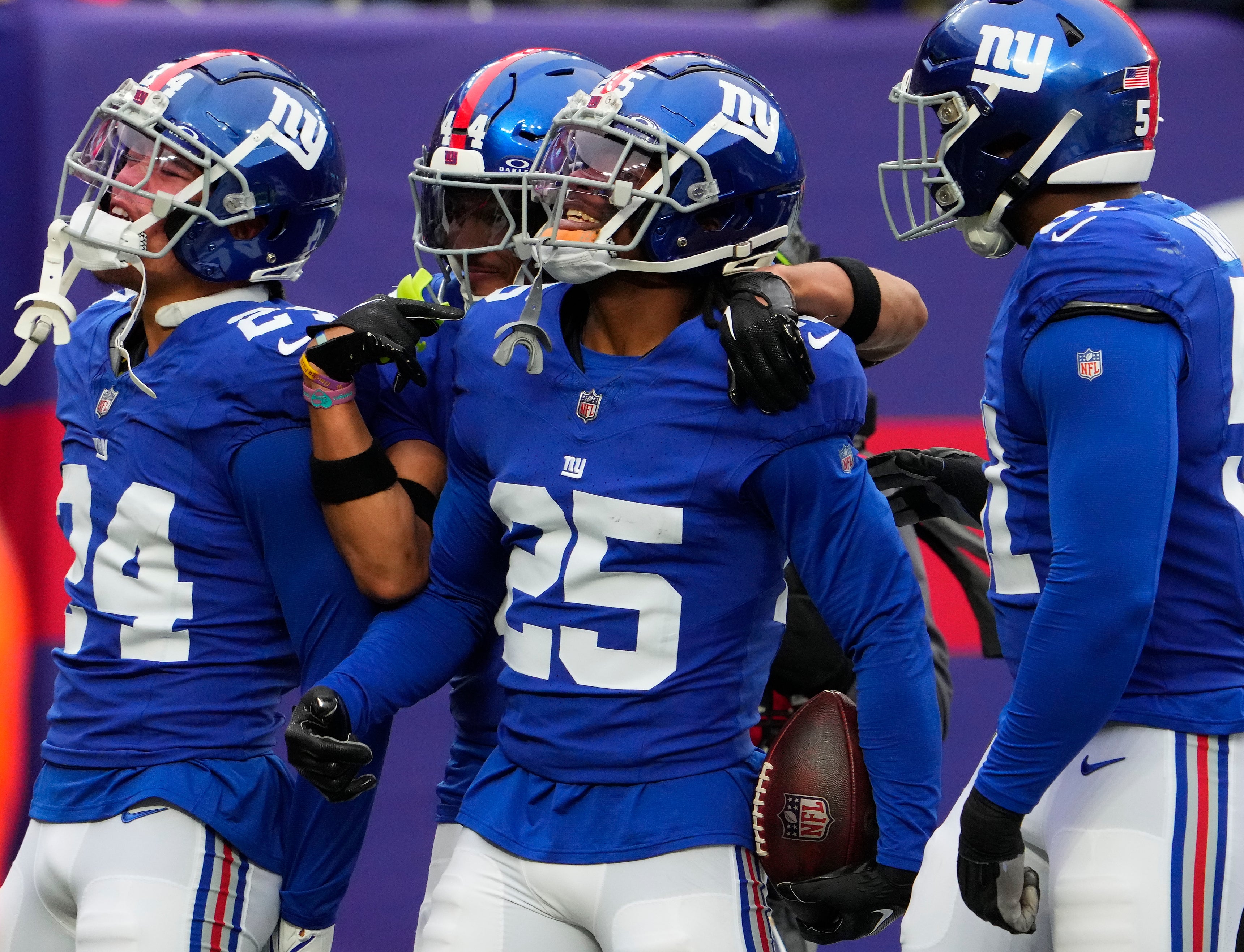 New York Giants defenders in blue uniforms celebrate a takeaway.