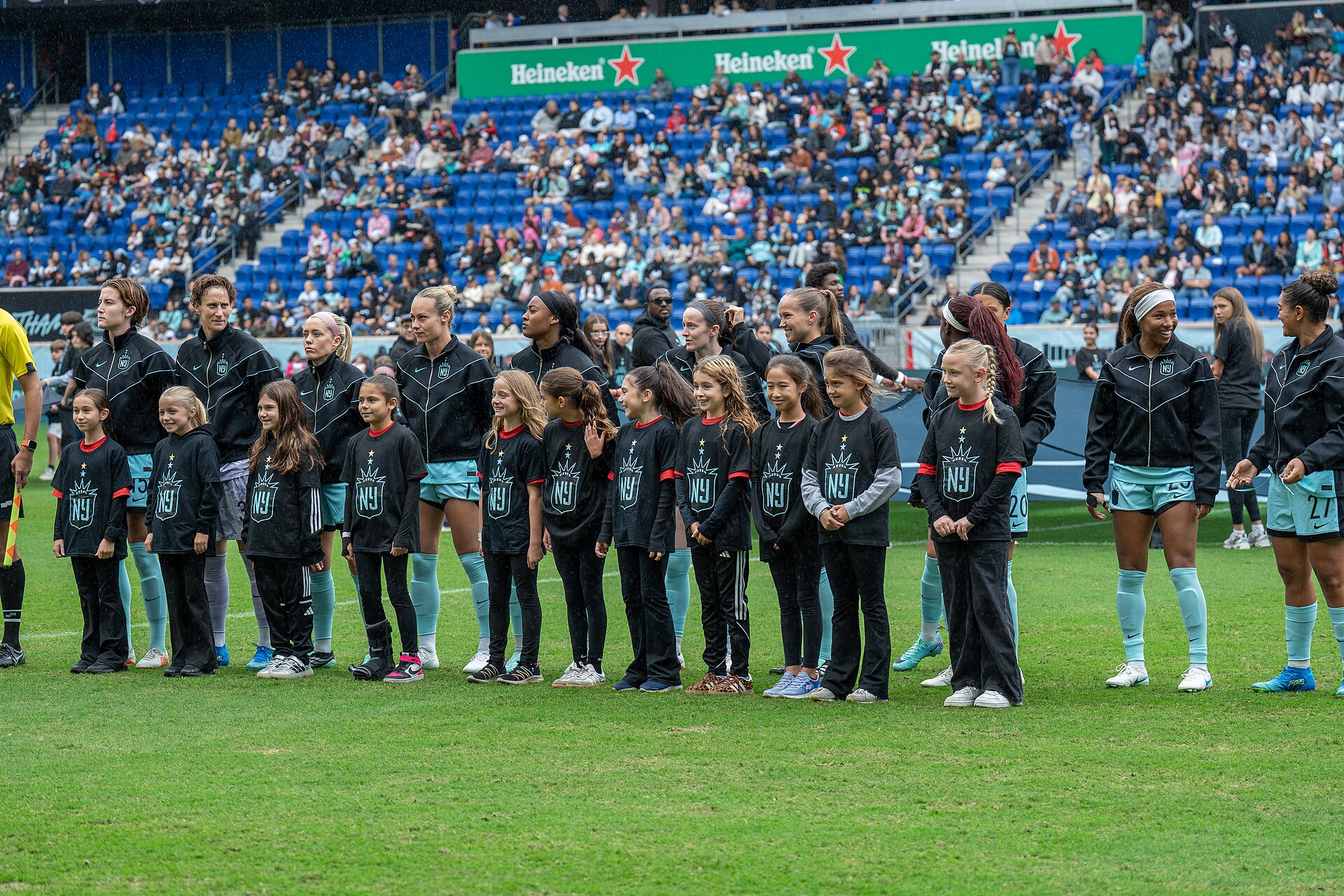 Gotham FC's starting eleven lines up with child mascots before the match against Angel City