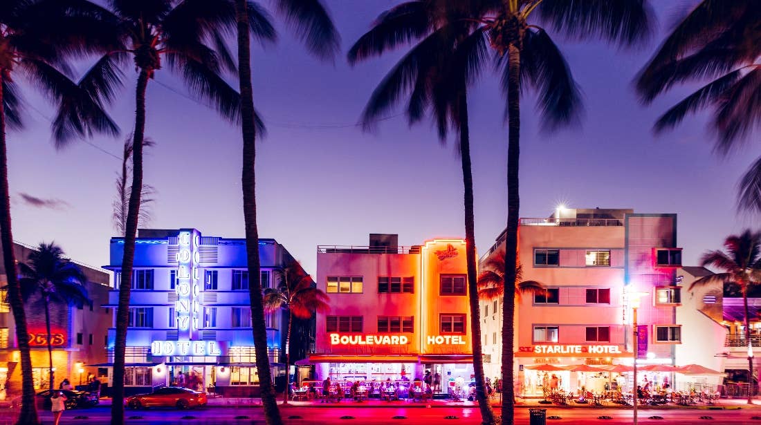 Neon lights glow over a Miami street at night, the real-world inspiration for GTA VI's Vice City
