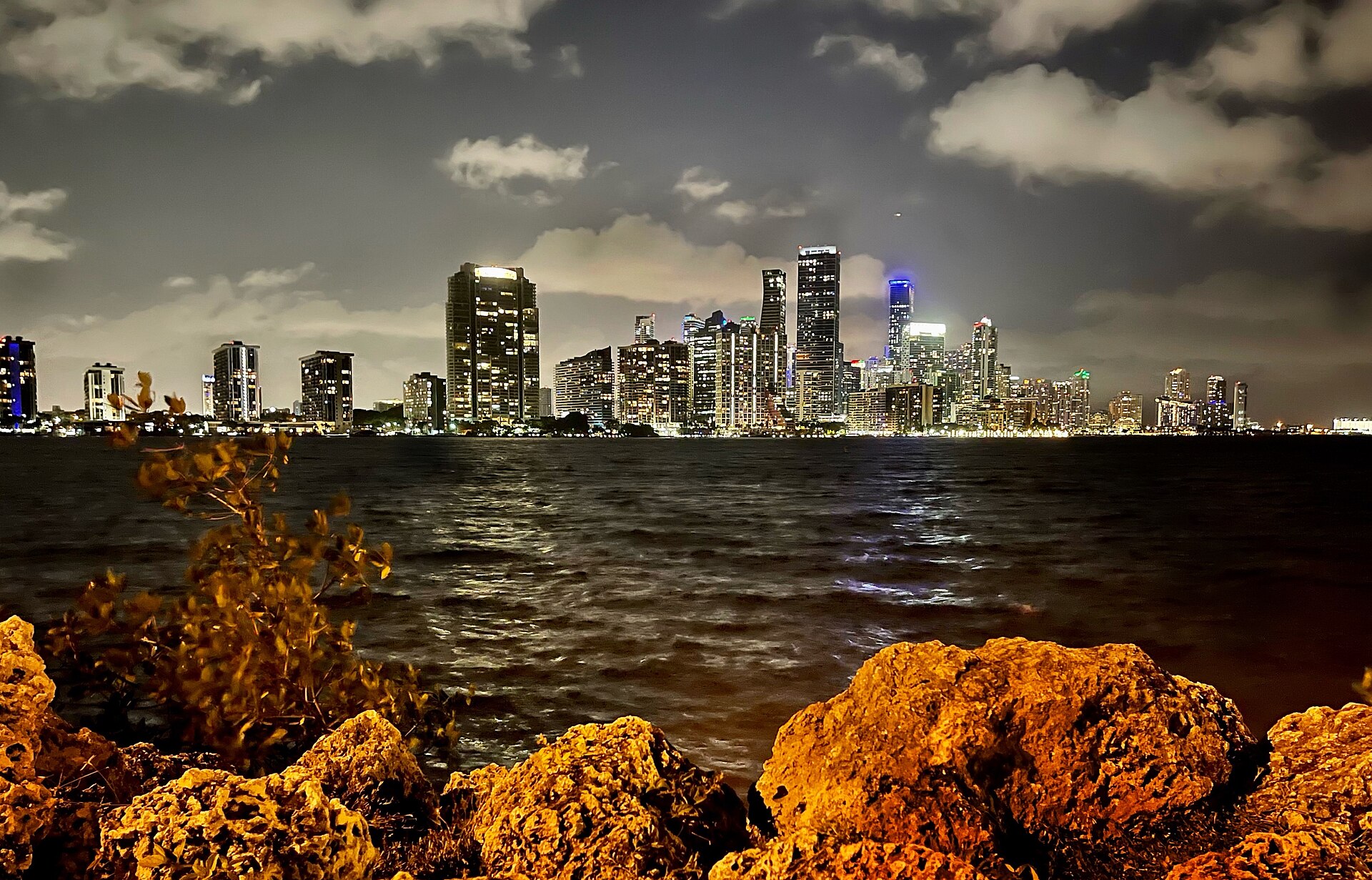 Downtown Miami's skyline glowing at night across Biscayne Bay — the real city behind GTA VI's Vice City