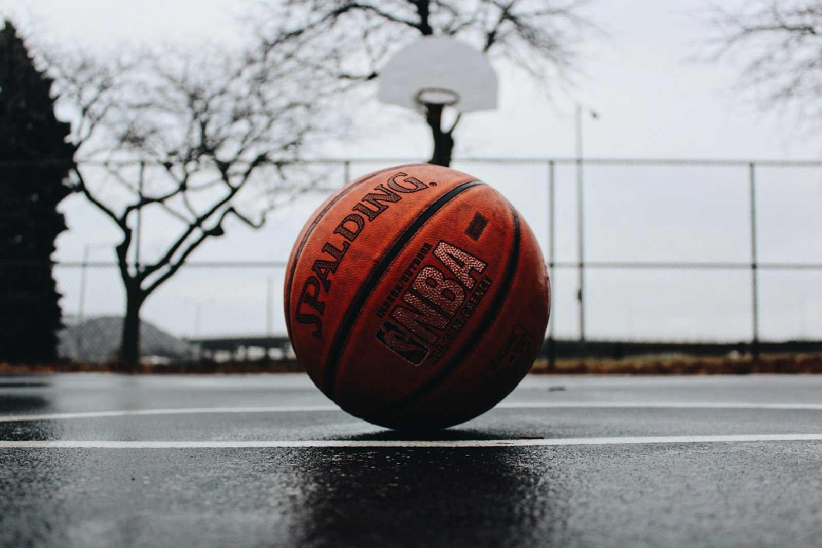 A shot drops through the hoop during an NBA game in a bright, packed arena