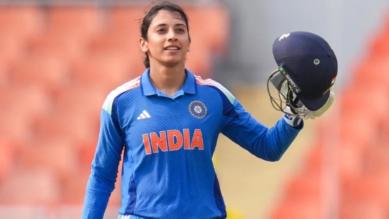 Smriti Mandhana raises her helmet celebrating in the India jersey