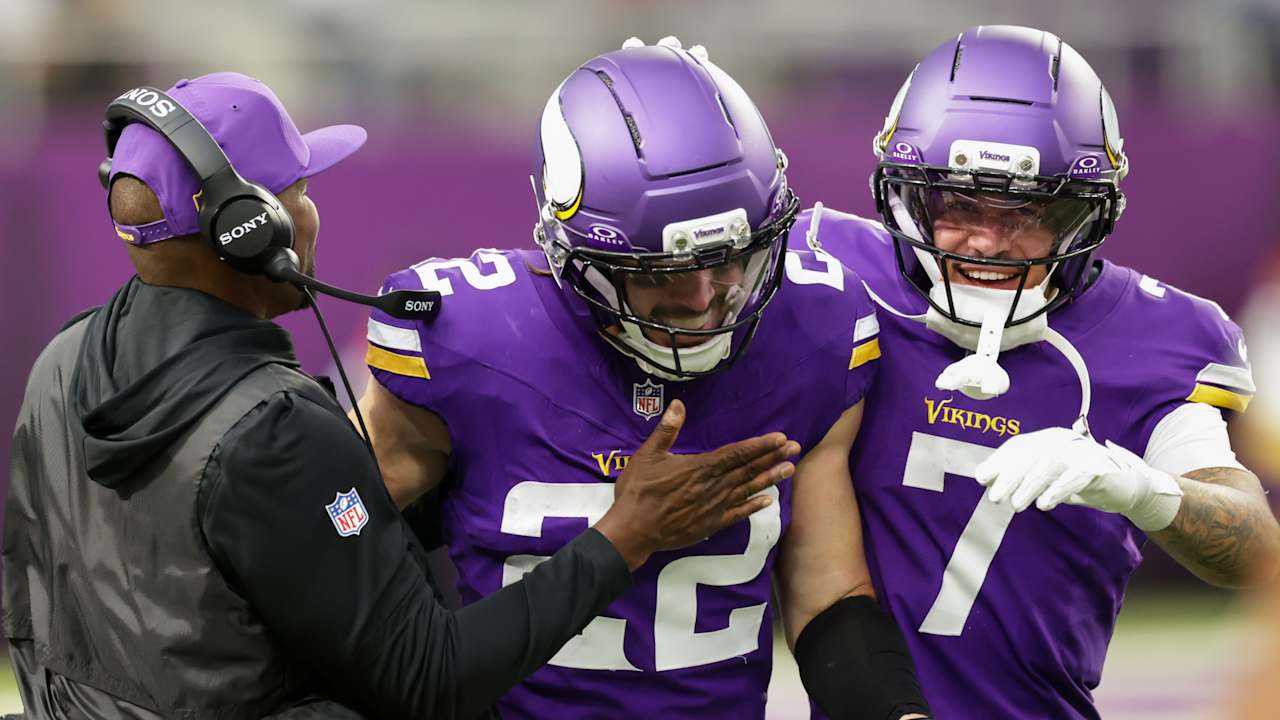 Harrison Smith of the Minnesota Vikings beams on the sideline as a Vikings coach greets him, with Byron Murphy Jr. celebrating beside him, at U.S. Bank Stadium
