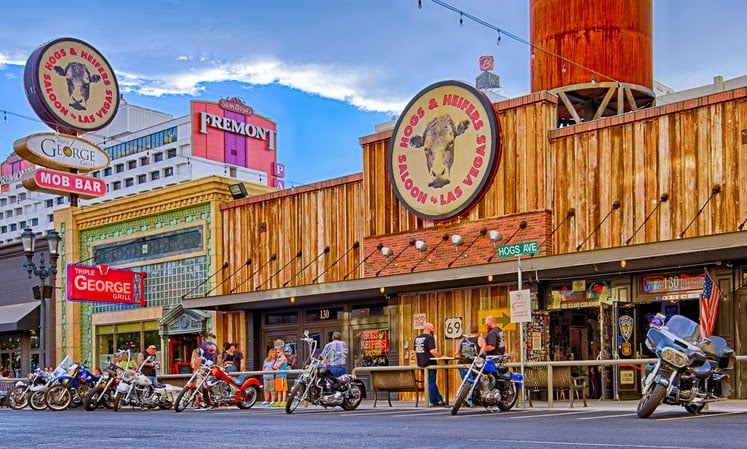 The Hogs & Heifers Saloon in downtown Las Vegas, with motorcycles lined up out front and the Fremont sign in the background