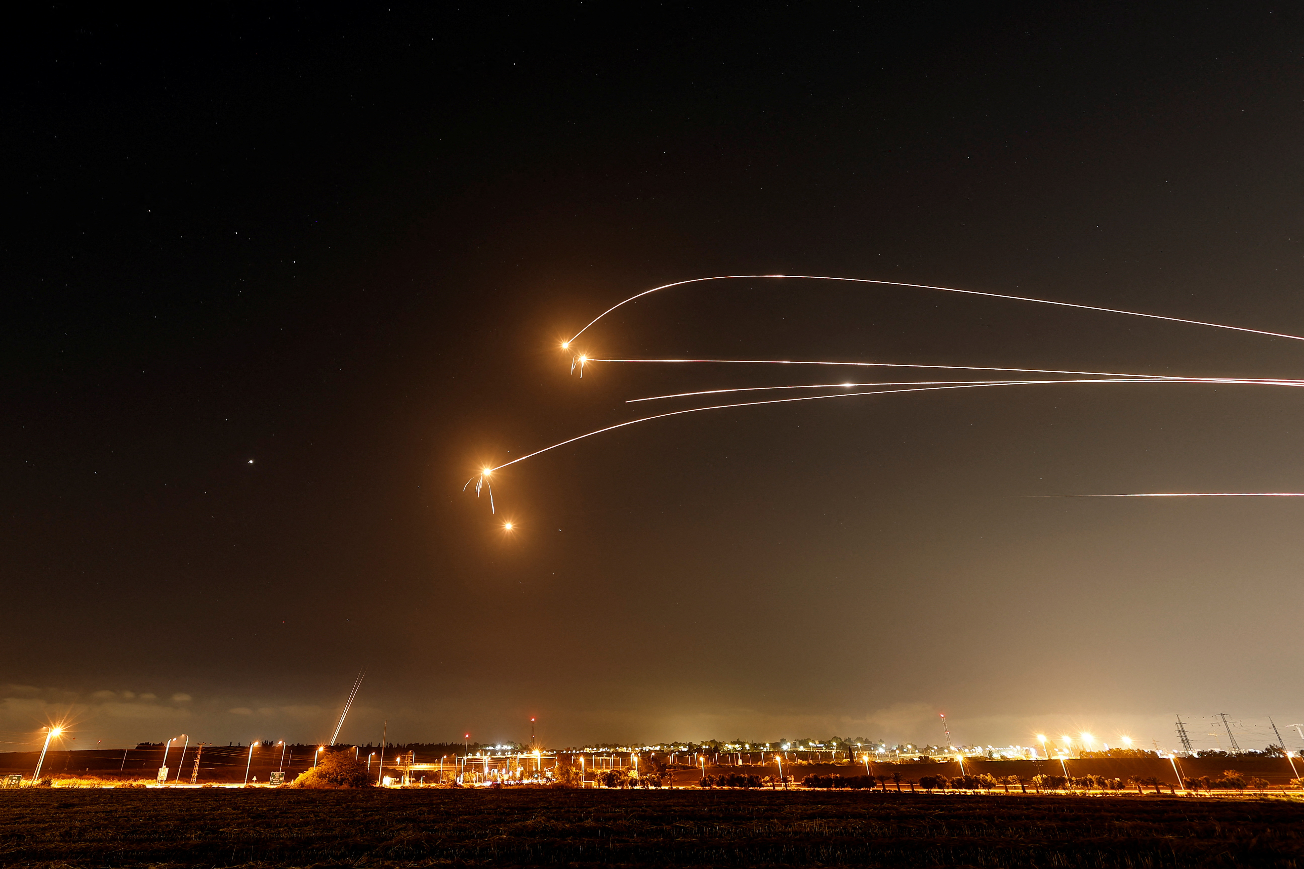 Missiles arc across the sky during a regional exchange — file photo