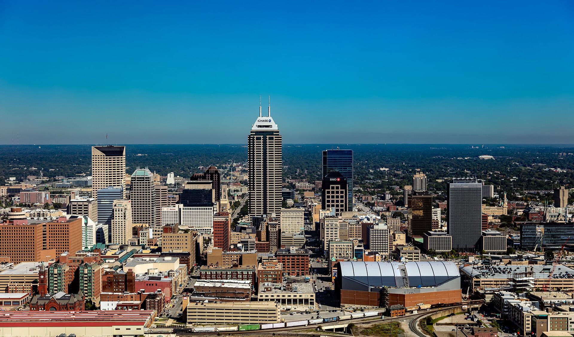 Daylight view of the Indianapolis skyline, downtown skyscrapers under a clear blue sky.