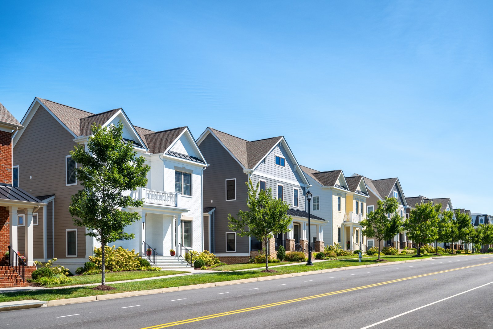 A residential street lined with suburban homes in daylight