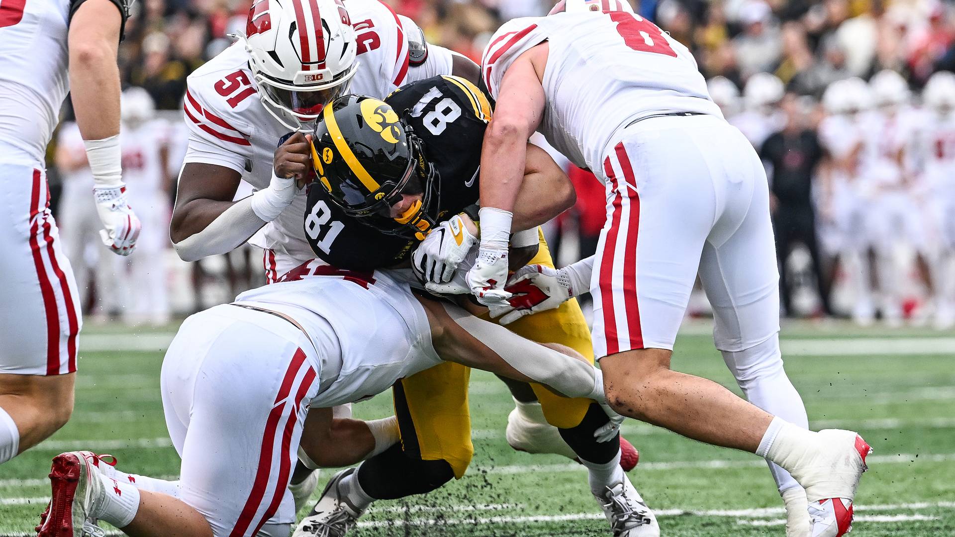 Wisconsin defenders Micheal Garner (51), Mason Posa (8) and Cooper Catalano (44) gang-tackle Iowa tight end DJ Vonnahme during the first quarter at Kinnick Stadium
