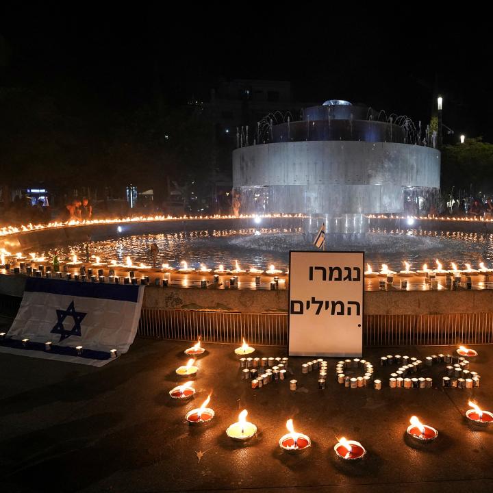 Memorial candles at a fountain in Israel at night